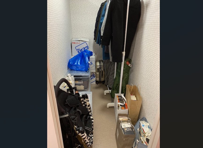 衣類や収納ケースを入れ、中央に通路を残したトランクハウス24江東千石の1.7帖の区画